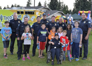 Group picture of 2016 National Night Out police officers, Chief for a Day, and balloon toss participants