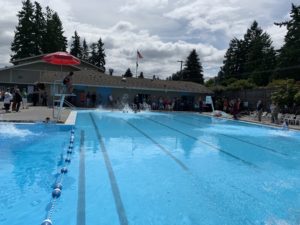 Color photo of the original Fircrest pool with swimmers jumping in the water